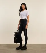 Calza deportiva negra con cintura elástica y una línea blanca vertical a lo largo de la pierna.