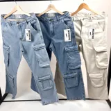 Pantalón jean celeste, corte holgado, con múltiples bolsillos tipo cargo en los laterales.