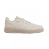 Championes Lacoste modelo L001 Set, color beige monocromático. Presentan un diseño de cuero con textura granulada, cierre de cordones al tono y suela de goma semitransparente con el logo de la marca grabado en el lateral.