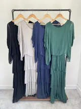 Vestido largo azul marino de seda italiana, con diseño de volados escalonados en la falda y una sobrecapa superior con mangas cortas amplias.