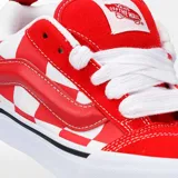 Championes Vans modelo Knu Skool, con diseño de tablero de ajedrez en rojo y blanco. Presentan una silueta robusta con lengüeta y cuello acolchados, la icónica banda lateral Sidestripe en relieve y suela de goma vulcanizada.