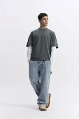 Remera de manga corta, color verde oscuro con efecto gastado o lavado, de corte holgado (boxy) y escote redondo.