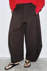 Pantalón de mujer color marrón oscuro, tiro medio, con cintura elástica y pierna ancha con mucho volumen y caída.