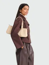 Cartera de hombro de diseño minimalista y rectangular, con correa ajustable mediante hebilla metálica y cierre superior. Presenta una estructura compacta y elegante.
