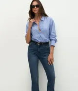 Pantalón bootcut de tiro alto confeccionado en jean de algodón con elastano. Presenta trabillas en la cintura, cierre frontal con botón, bolsillos clásicos con bolsillo reloj y bajo acampanado.