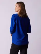 Buzo tejido color salmón de hilado fino, marca Cable & Gauge. Escote redondo con calados. Manga ¾, modelo dolman con aplique de botones dorados.