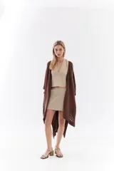 Ruana de punto color beige con detalles texturizados y tramados abiertos, ligera y versátil.