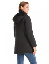 Campera capitoneada de largo midi en color bordó, con diseño de rombos en el cuerpo y mangas, y costuras diagonales en los laterales. Cuenta con cierre frontal, capucha desmontable con interior suave y panel entallado en la cintura.