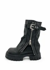 Botas de caña media color negro, con suela track dentada, cierre frontal con cremallera metálica y tira con hebilla ajustable en la parte superior.