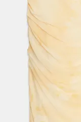 Vestido midi de tejido mesh color amarillo pálido con estampado tipo tie-dye o acuarela en tonos más oscuros. Presenta escote en pico, tirantes finos ajustables y drapeado frontal.