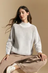 Polera de tejido acanalado en color marrón con detalles de líneas en tono lila, cuello alto y mangas largas con diseño raglán.