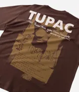 Remera boxy de algodón color marrón, con estampado trasero inspirado en Tupac y el concepto "The Rose", incluyendo texto y una imagen abstracta.