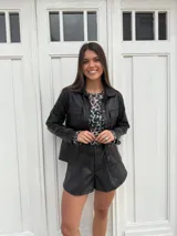 Chaqueta metalizada dorada con cuello camisero, cierre frontal con botones y bolsillos de parche en el pecho.