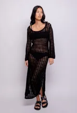 Vestido largo negro de tejido de punto calado, con escote redondo y mangas largas acampanadas.