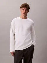 Remera de manga larga Calvin Klein confeccionada en algodón con tejido interlock. Presenta cuello redondo y un sutil logo de la marca bordado en el pecho.