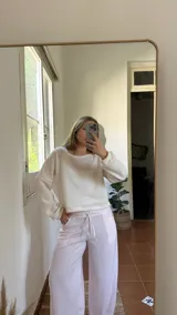 Blusa color crudo de tejido suave, con escote redondo y puños en las mangas.