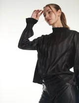 Blusa de satén negro con diseño de rayas verticales tono sobre tono. Presenta cuello alto con detalle de fruncido tipo smock, mangas largas con puños elásticos y terminación con volado.