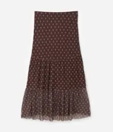 Falda midi de tul con estampado de corbatas, cintura elástica y diseño con volados. Presenta un forro más corto que crea un efecto de transparencia en el ruedo.