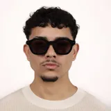 Lentes de sol con armazón de acetato negro y diseño de marco cuadrado con bordes redondeados. Cuentan con cristales oscuros con protección UV400.