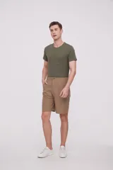 Bermuda de corte recto y diseño minimalista, confeccionada en tejido técnico de poliéster. Presenta cintura elástica con cierre de botón frontal, bolsillos laterales y un bolsillo pequeño adicional en el lateral izquierdo.