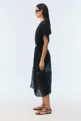 Kimono largo de algodón negro con punto calado, calce amplio, hombros caídos, mangas cortas, aberturas laterales y terminación desflecada en el ruedo.