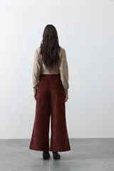 Pantalón de pana de corte wide leg, color marrón oscuro, con calce relajado y detalle de bordado en el borde de los bolsillos delanteros.
