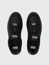 Zapatillas Diesel modelo S-Oval Skate, color blanco hueso o crema, de corte bajo y estilo skate. Presentan paneles superpuestos, forro interior de felpa y suela gruesa con textura. El logo DIESEL es visible en la lengüeta y un dije metálico con logo adorna los cordones.