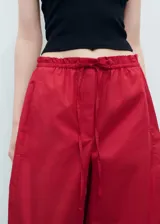 Pantalón rojo de corte holgado y pernera ancha, con cintura elástica fruncida y cordón ajustable.