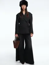 Blazer de corte sastrero con diseño de doble botonadura y solapas clásicas. Presenta un patrón de rayas verticales finas, hombros estructurados y bolsillos con solapa en la parte frontal.