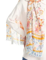 Pashmina estampada con diseño floral multicolor sobre fondo blanco, con terminación deflecada en los bordes.