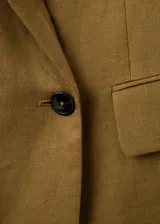 Blazer de lino color verde militar, de corte recto y diseño estructurado, con cuello en pico y solapas de muesca. Presenta mangas largas con puños abotonados, bolsillos con solapa en la parte delantera y cierre frontal de botonadura doble con abertura posterior en el bajo.