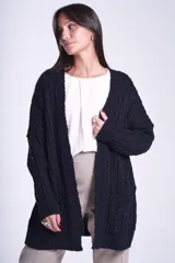 Cárdigan negro tejido con diseño de ochos, corte holgado y bolsillos frontales.