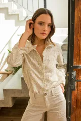 Camisa de lino con estampado floral liberty, cuello clásico, cierre frontal con botones y detalle de aplique bordado en encaje sobre el pecho.