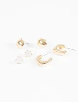 Set de tres pares de aros dorados: un par de aros tipo botón con piedra blanca, un par de aros tipo argolla gruesa y un par de aros tipo argolla cuadrada.