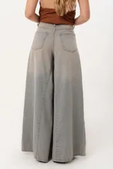 Jean súper campana de tiro alto, color celeste vintage, con pierna extra ancha y caída fluida. Cuenta con bolsillos delanteros y traseros, y cierre frontal con cremallera y botón metálico.