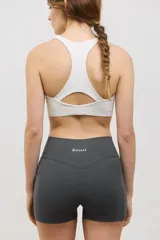 Minishort deportivo de tiro alto con bolsillos laterales, confeccionado en tejido elastizado de compresión media.
