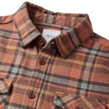 Camisa de franela a cuadros color ladrillo, con dos bolsillos frontales con solapa abotonada y mangas largas.