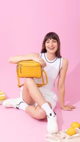 Bandolera color amarillo mostaza con diseño texturizado geométrico en el frente y bolsillo con cierre. Cuenta con un bolsillo trasero con cierre y correa extensible.