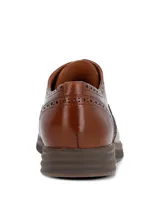 Zapato tipo Oxford estilo brogue color marrón, con detalles de perforaciones decorativas en la puntera y laterales. Cuenta con cierre de cordones y suela de goma con diseño deportivo.