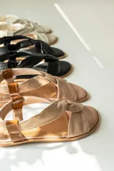 Sandalias chatitas de cuero en tono nude, con diseño de tiras cruzadas en el empeine y elástico en el talón para mayor ajuste. Presentan una plantilla acolchada y detalles en cuero charolado en la parte posterior.