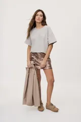 Remera gris de fit amplio, con mangas cortas y cuello redondo. Presenta efecto lavado y estampa frontal con aplicación de strass con la frase "fiesta mode on".