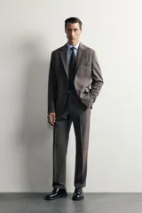 Blazer regular fit de Zara, confeccionada en tejido gris con mezcla de lana, con solapas de muesca, cierre de botonadura frontal y bolsillos con solapa en la cadera.