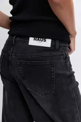 Pantalón de jean color negro lavado, de corte holgado y tiro medio, con costuras reforzadas en las rodillas.