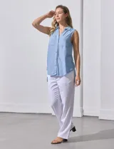 Camisa sin mangas color beige, marca Zac & Rachel, confeccionada en lino. Presenta escote en V, abertura frontal con botones, dos bolsillos delanteros y terminación con botones en los laterales.