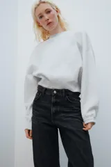 Jeans de tiro medio con diseño de volumen crop y perneras curvas. Presenta cinco bolsillos, cierre frontal con cremallera y botón metálico.