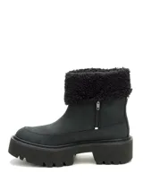 Bota de caña media color negro, confeccionada en nubuck, con cuello de pelo sintético y suela de plataforma dentada de goma.