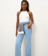 Pantalón recto de jean color azul oscuro, tiro alto, con costuras aparentes en contraste, trabillas en la cintura, cierre tradicional y bolsillos.