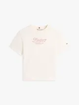 Remera de manga corta y cuello redondo color blanco marfil de Tommy Hilfiger, con el logo gráfico bordado en el pecho en tono rosado y la bandera de la marca bordada en la manga.