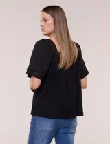 Blusa de corte holgado color marfil, confeccionada en mezcla de modal y algodón, con escote cuadrado y mangas cortas adornadas con detalles de puntilla calada.