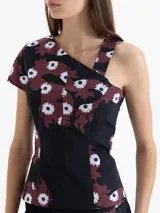 Top asimétrico confeccionado en popelina 4way con estampado exclusivo de dragones y flores. Un lateral tiene bretel fino y el otro manga corta, creando un efecto de un solo hombro cubierto.